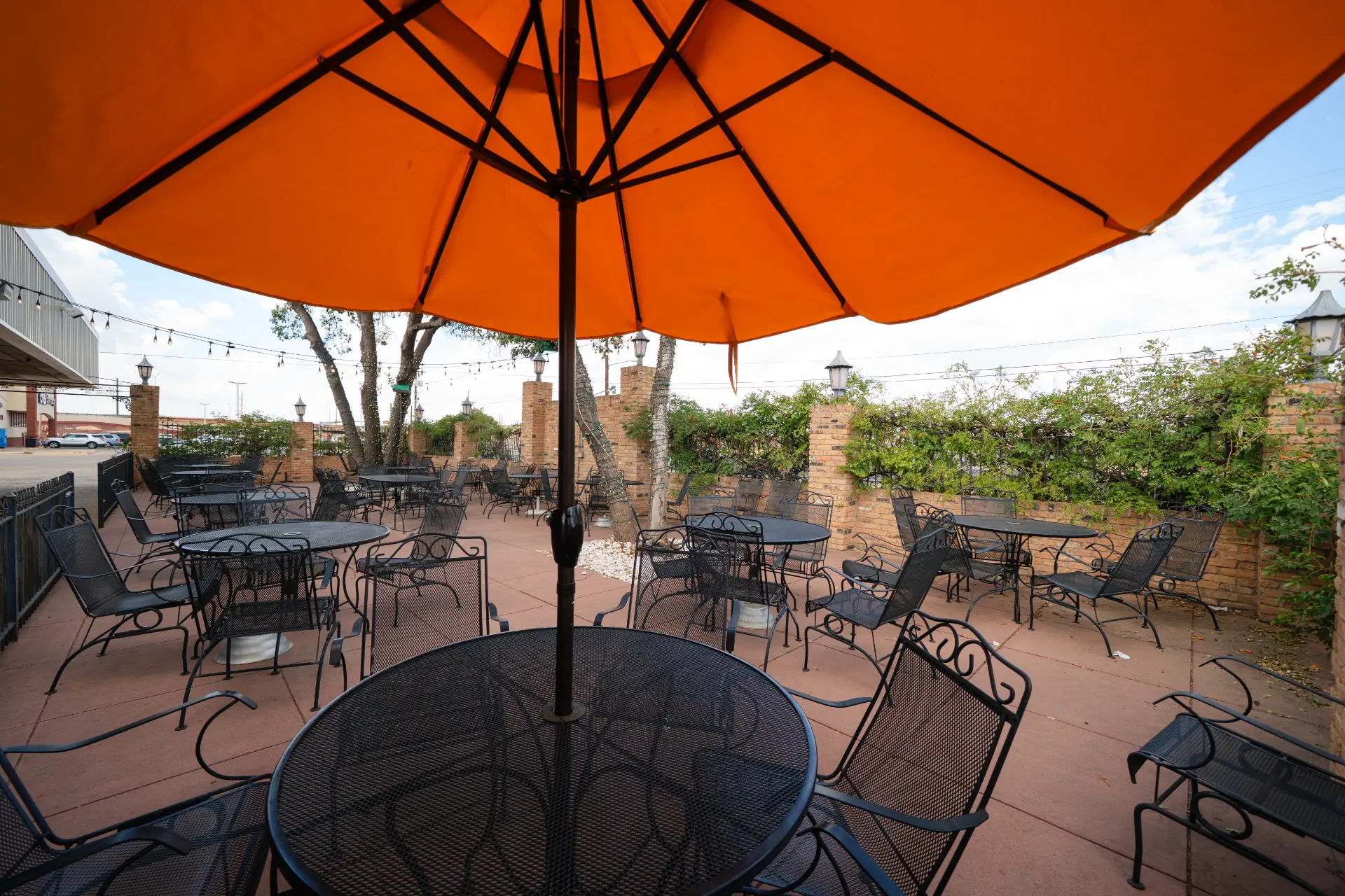 Patio under an orange umbrella with string lights